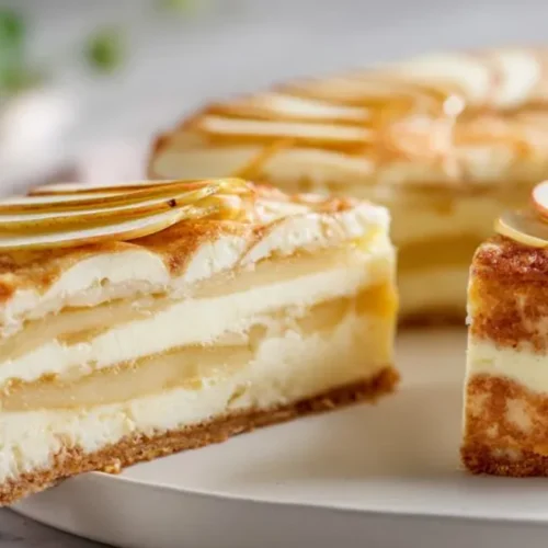layered apple cream cake with thin apple slices on top and creamy filling between soft cake layers