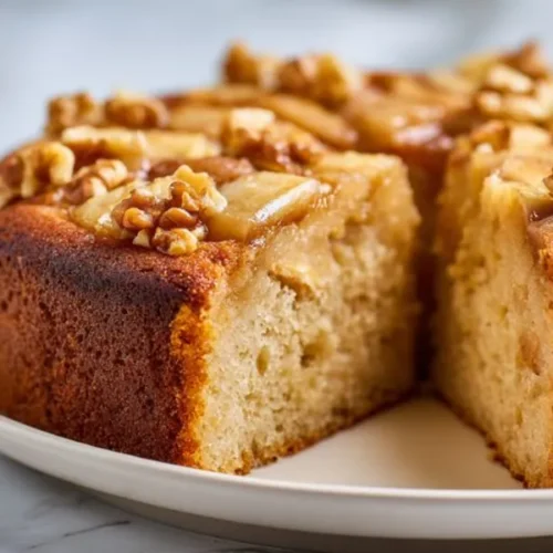 moist apple walnut cake with caramelized apples and crunchy walnut topping on plate